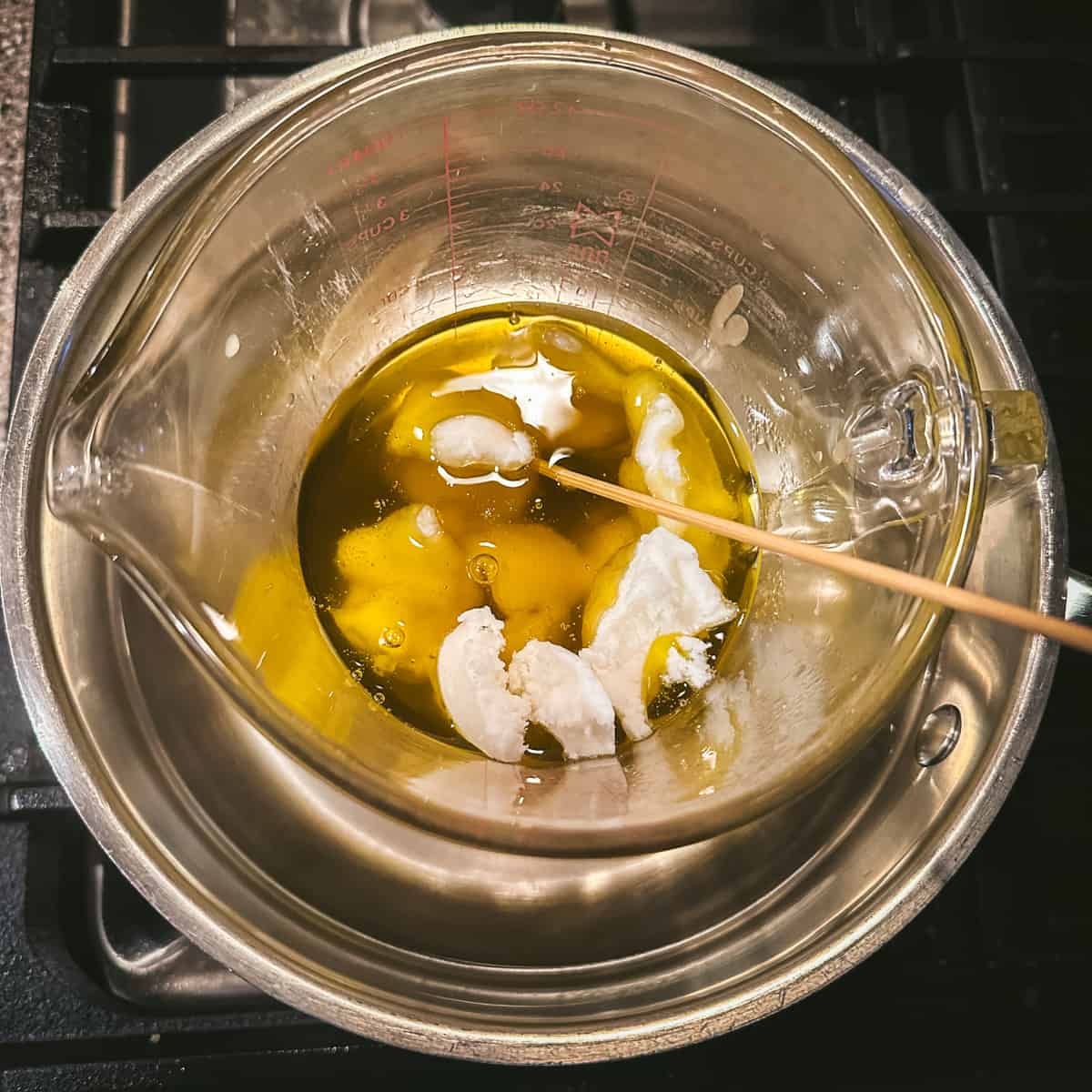 A makeshift double boiler  with melted oils, beeswax, and shea butter. 
