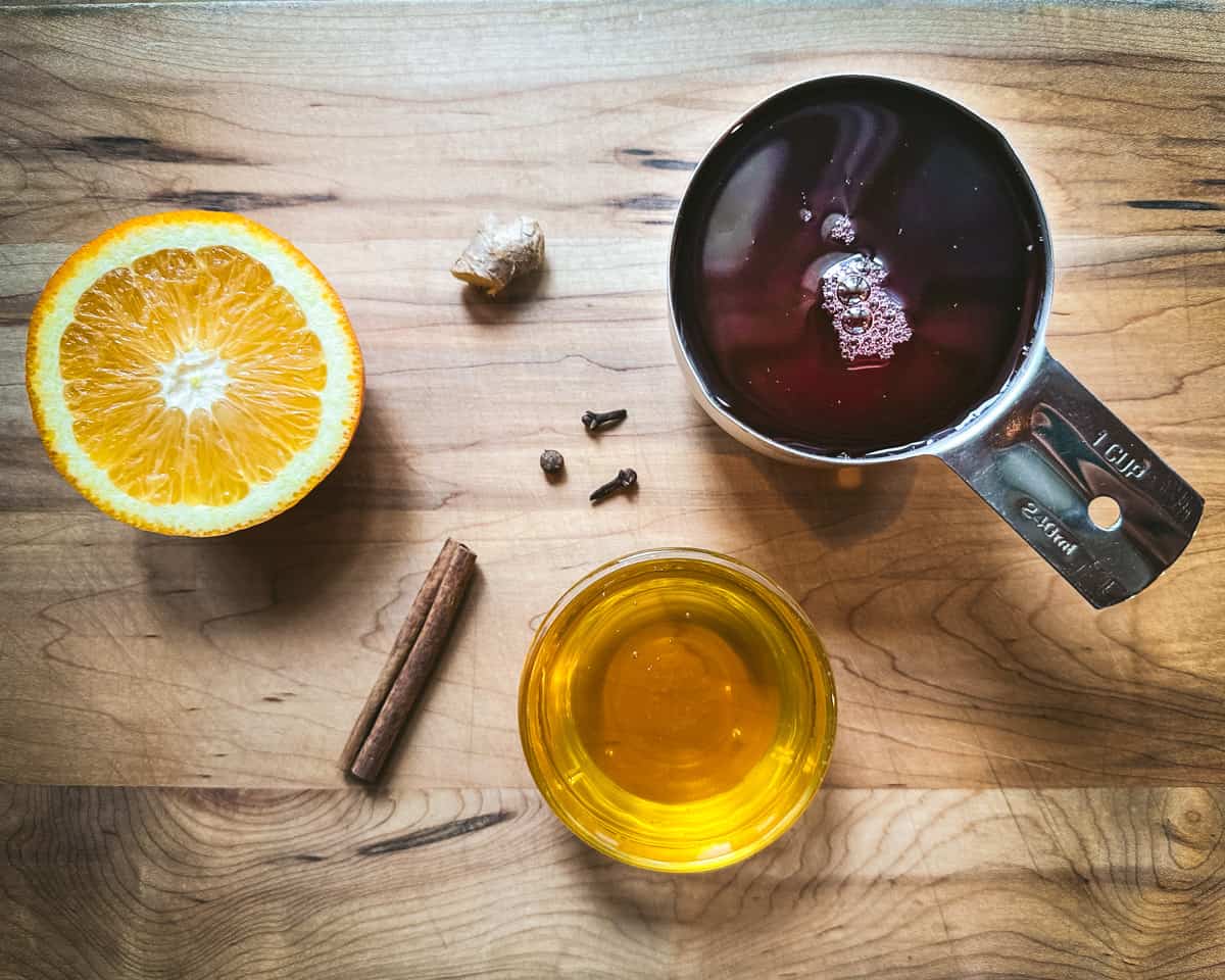 Ingredients for spiced cranberry syrup on a wood surface, top view. 