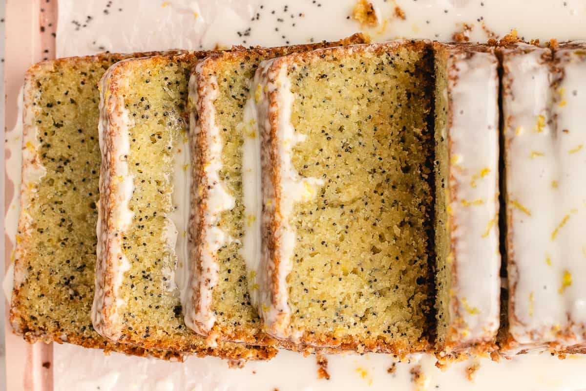 Lemon poppy seed loaf, sliced with some slices laying down, top view. 