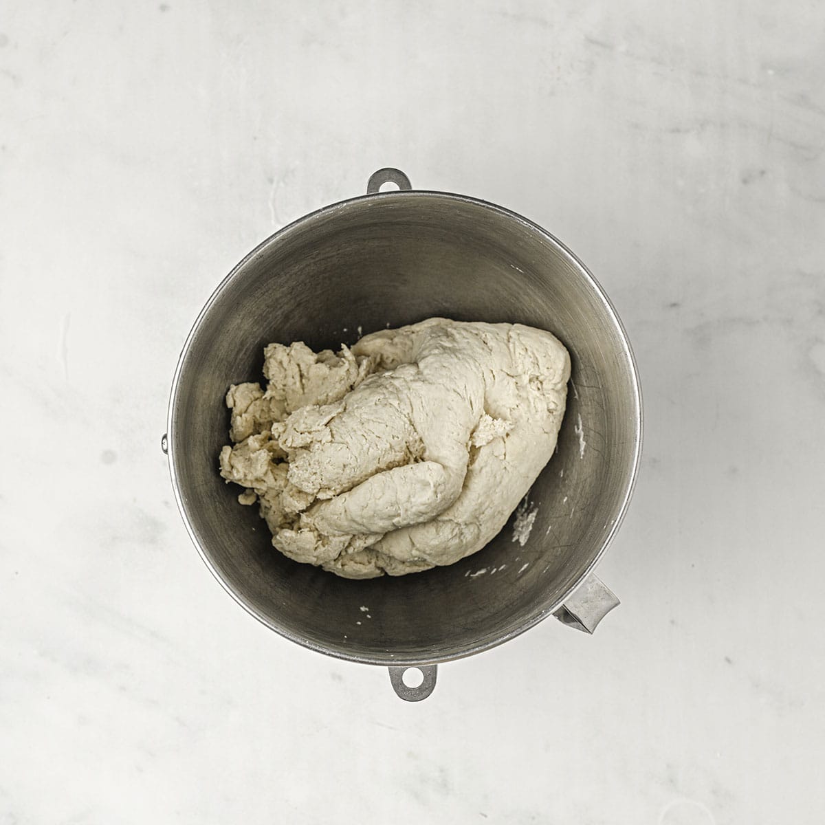 Rough dough kneaded by a stand mixer, in the bottom of the mixer bowl, top view. 