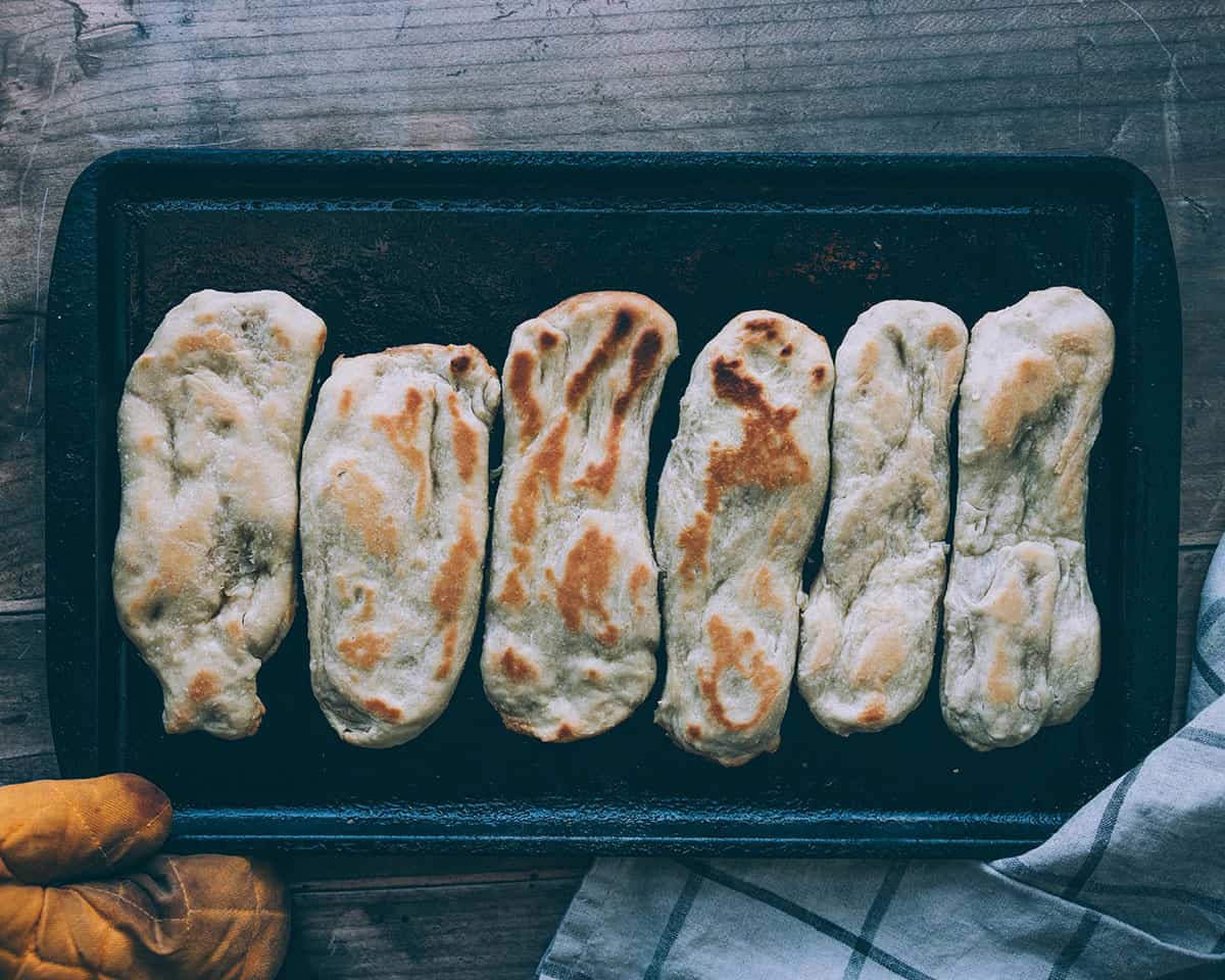 Baked sourdough naan on a sheet pan. 