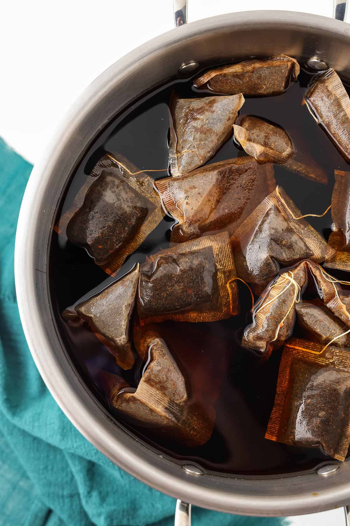 Tea bags steeping in a large pot. 