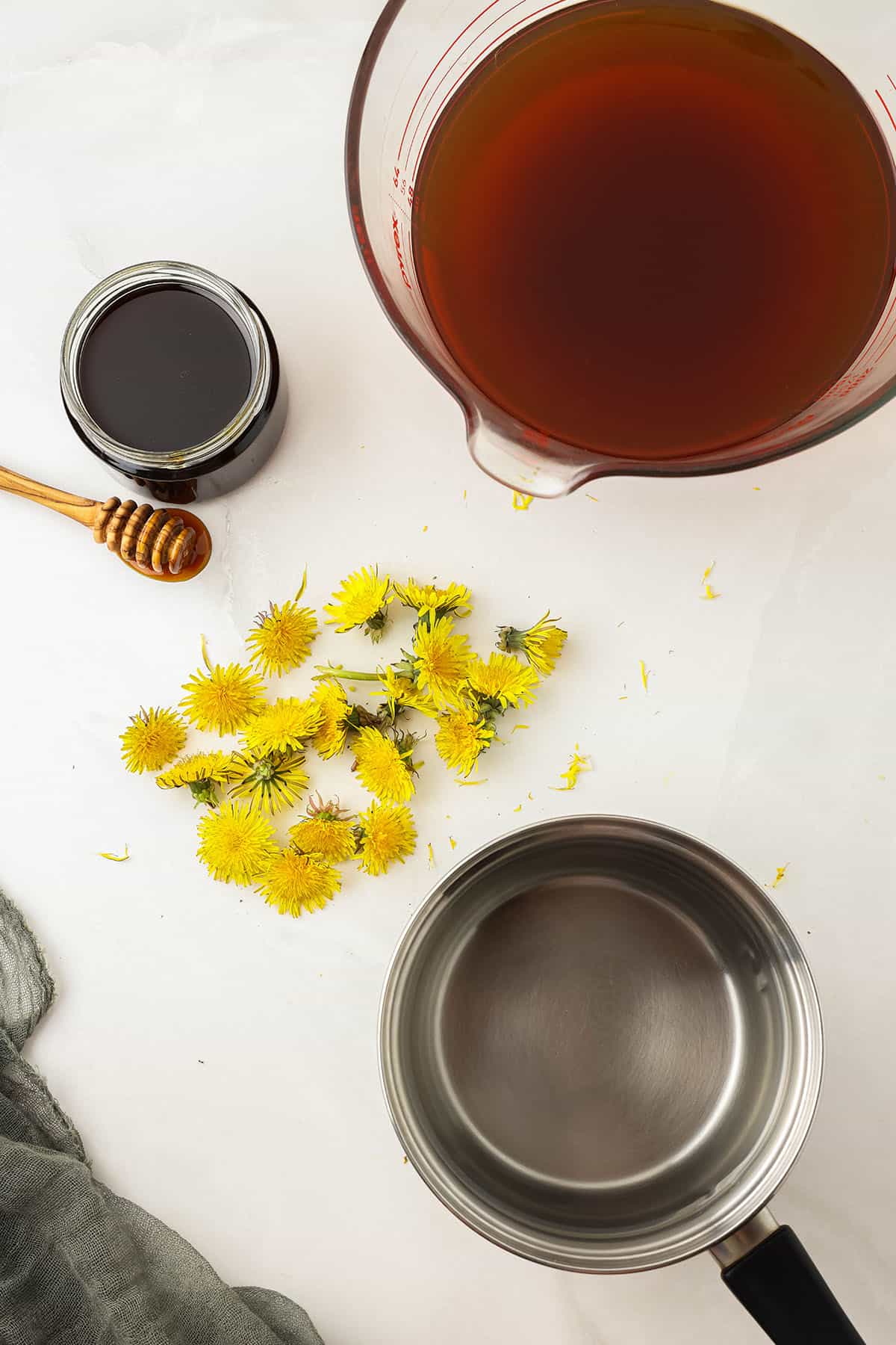 Dandelion kombucha ingredients on a white countertop, top view. 