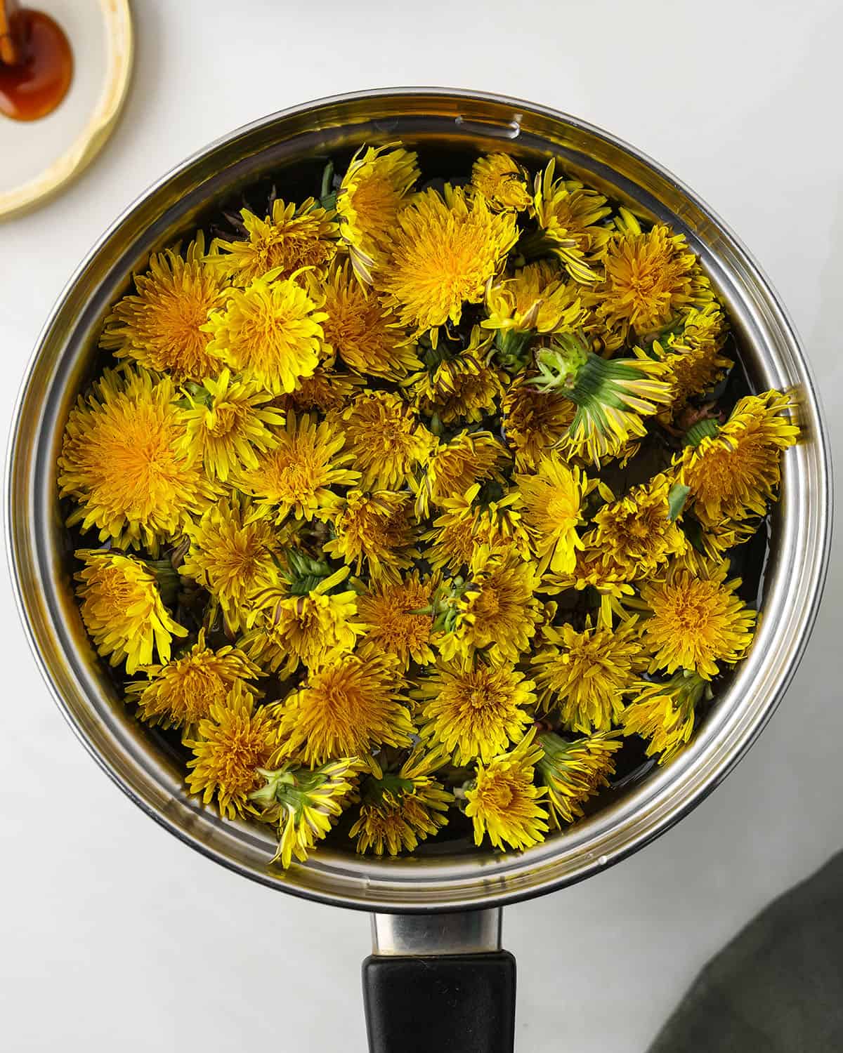 Fresh dandelion flowers in a pot, top view. 