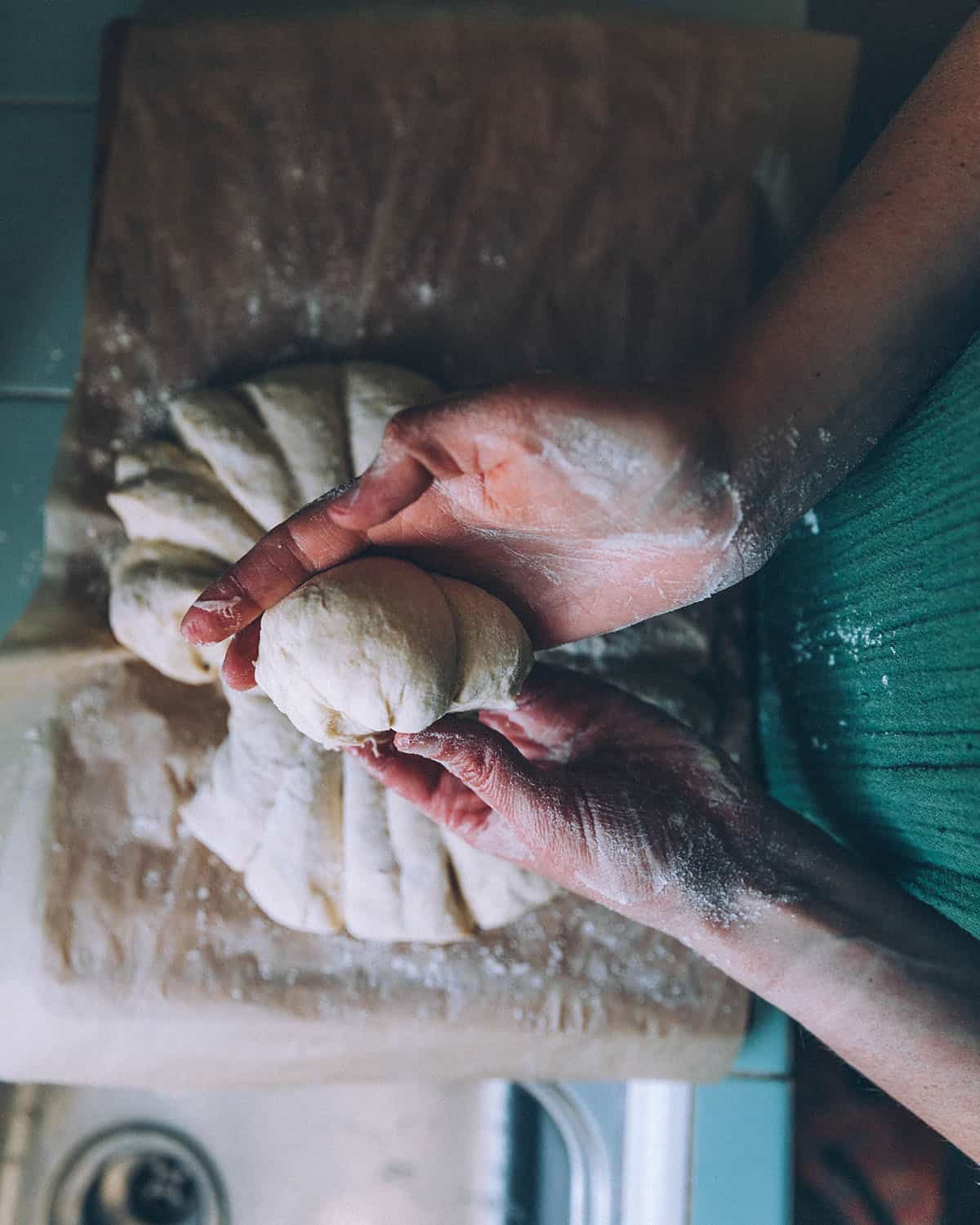 Sourdough naan dough being split into separate pieces. 