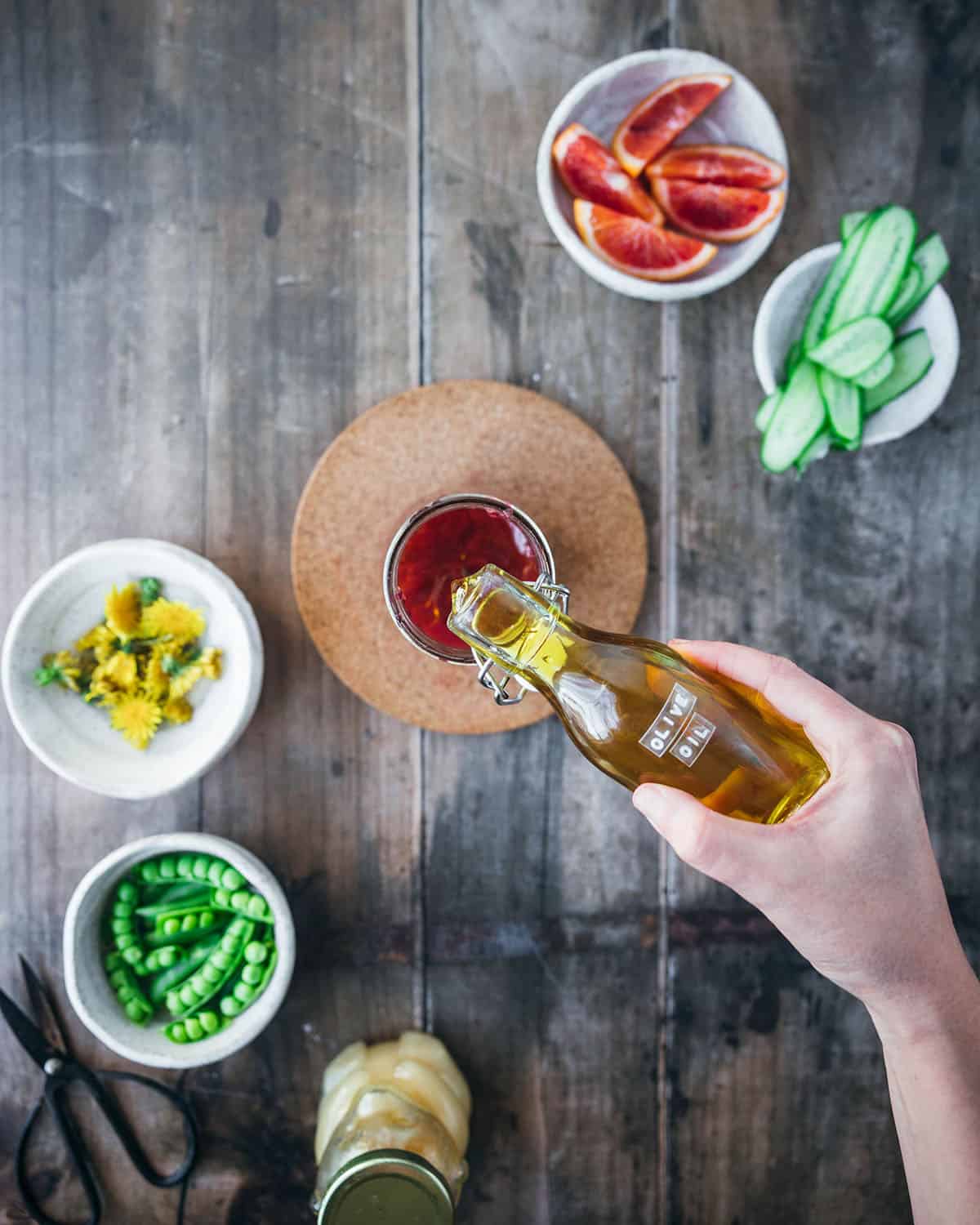 Olive oil is poured into the dressing jar. 