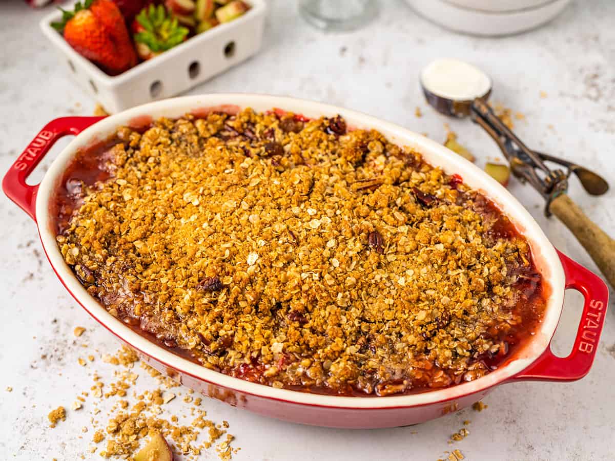 Baked and golden crisp top showing on the rhubarb crisp in a baking dish. 