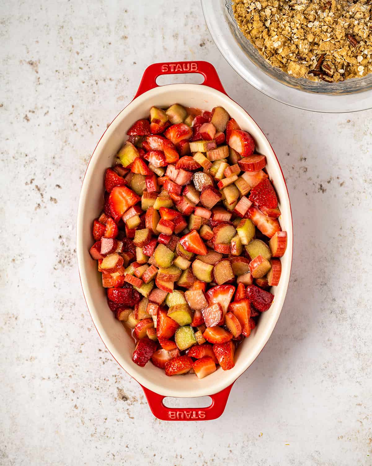 Rhubarb and strawberry mixture in a baking dish, top view. 