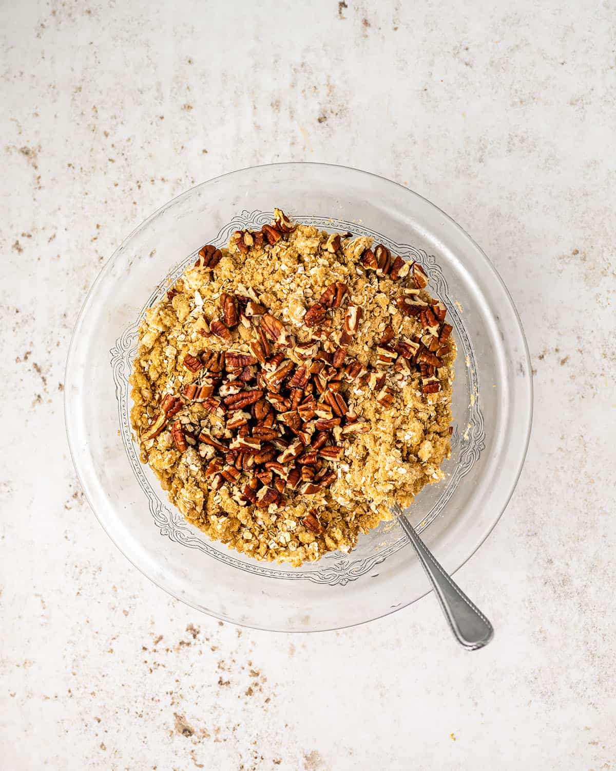 Oatmeal, nuts, and other ingredients in a bowl to make the crisp topping. 