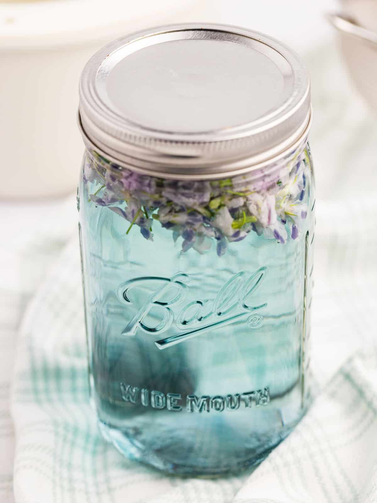 A jar of blue violet tea steeping. 