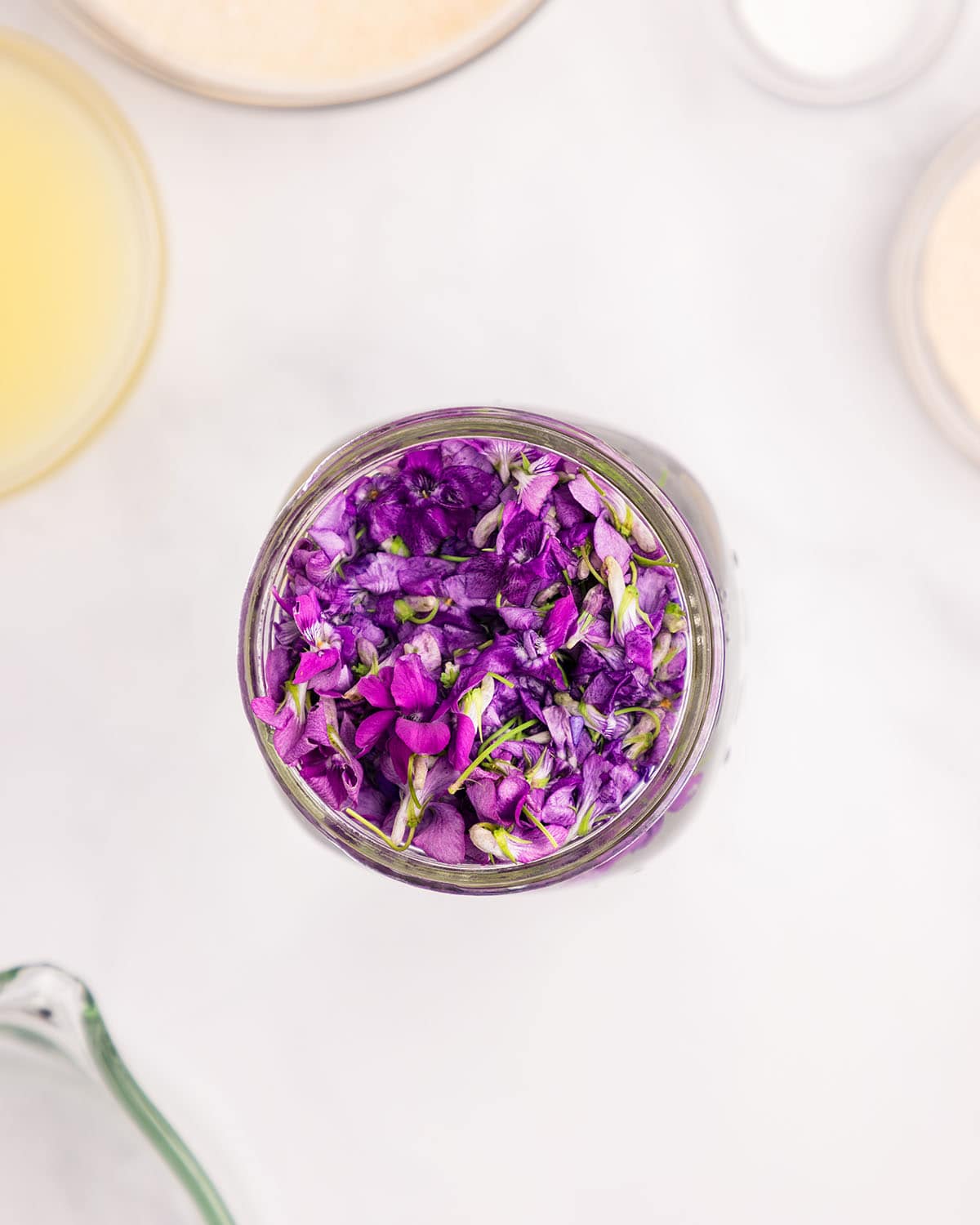 A jar of wild violet blossoms, top view. 