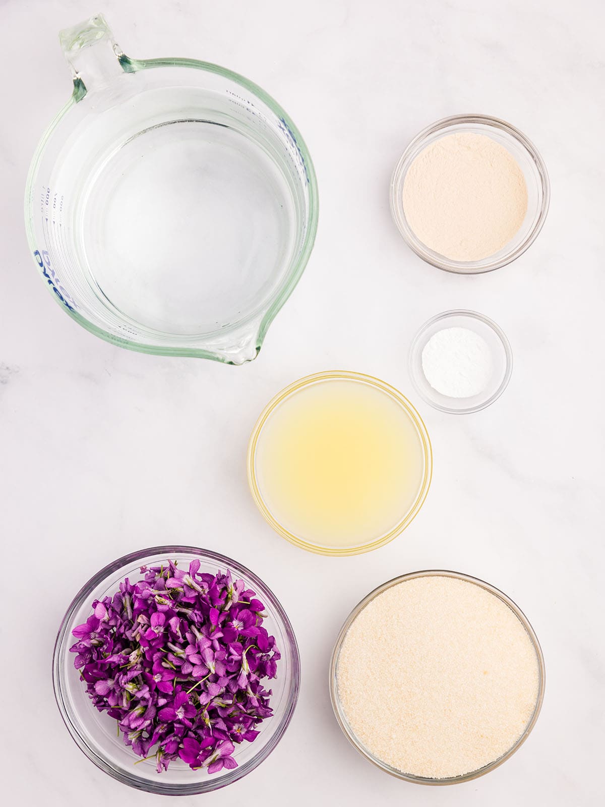 Wild violet jelly ingredients in bowls, top view. 