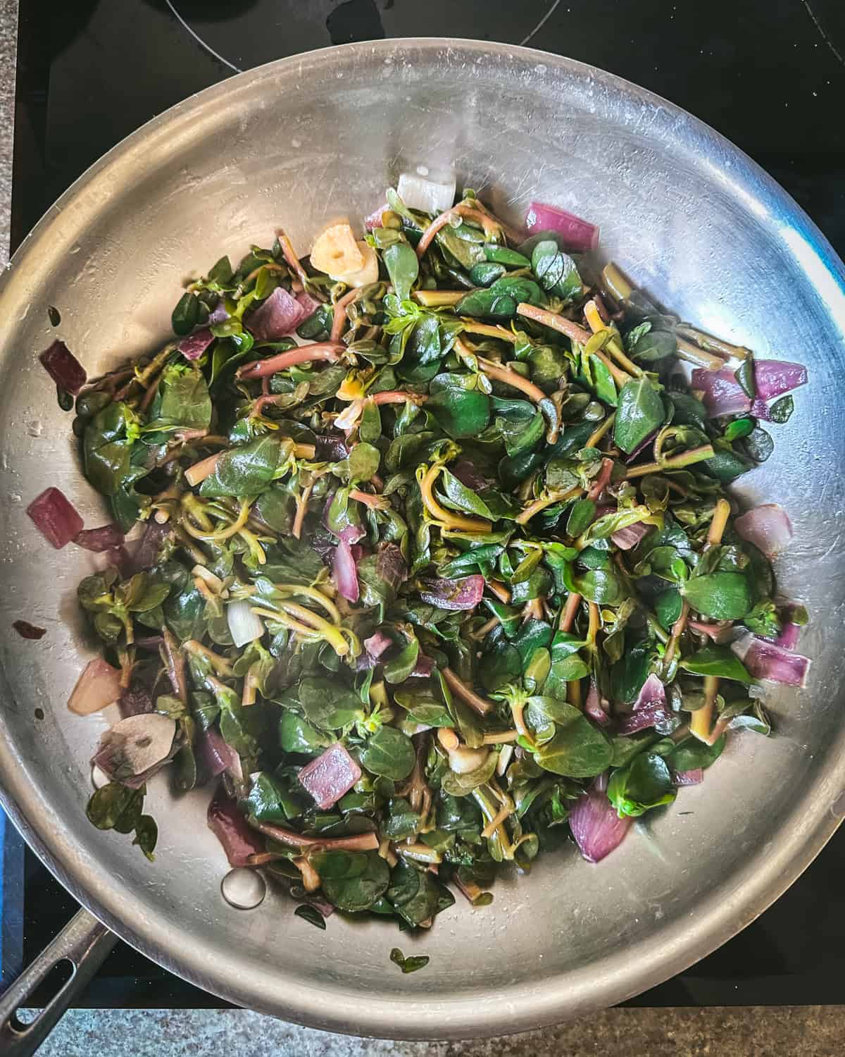 Sautéed purslane in pan.
